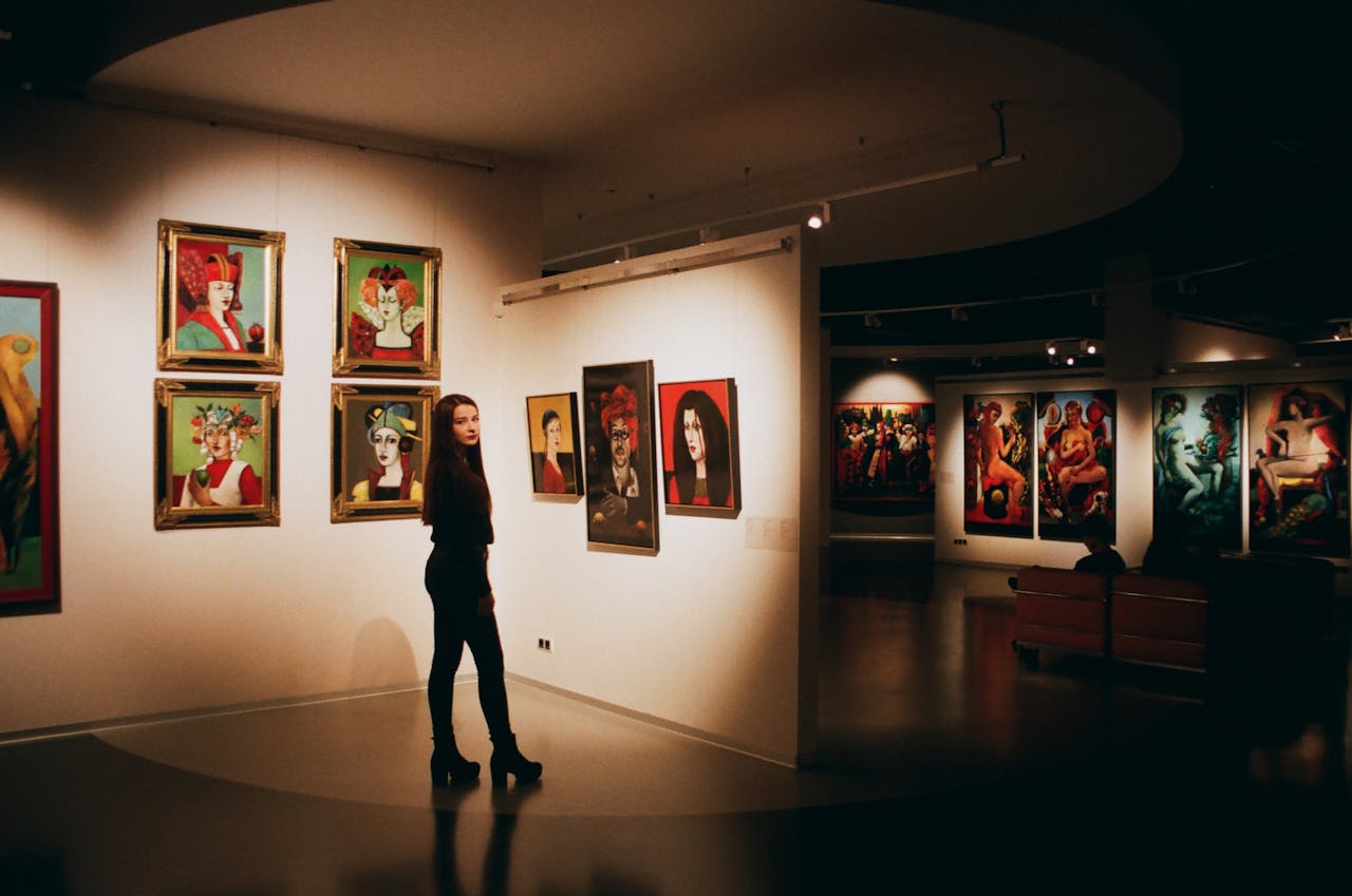 Home A woman admiring colorful paintings in a contemporary indoor art exhibition.
